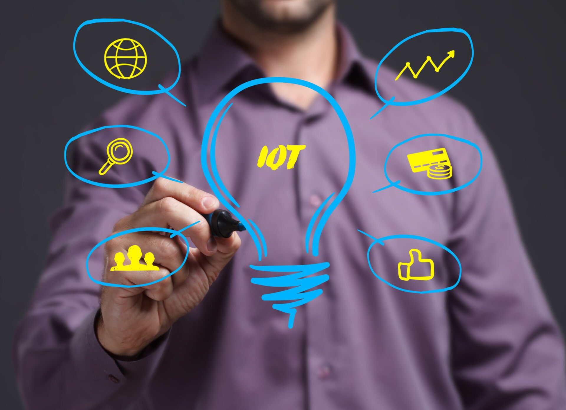 An image of a businessman drawing a glowing lightbulb labeled IoT.